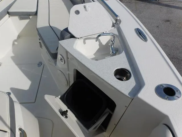 Slide: The Image of 2024 Stingray 216CC boat interior with sink, storage, and seating. - 25