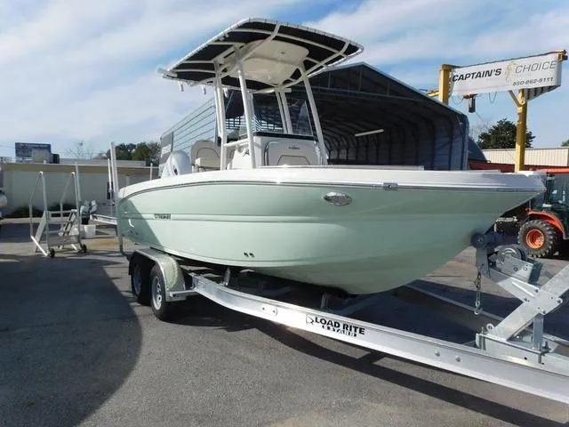 Slide: The Image of 2024 Stingray 216CC boat on trailer, parked outdoors near a storage facility. - 3