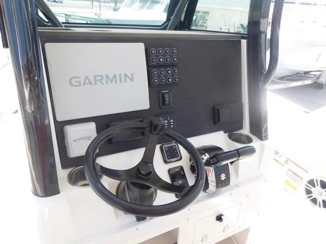 Slide: The Image of 2024 Stingray 253CC boat dashboard with Garmin navigation system and steering wheel. - 25