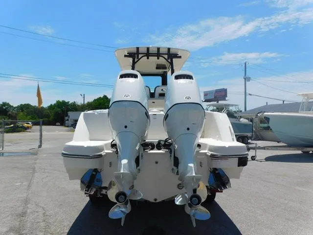 Slide: The Image of 2024 Stingray 253CC boat with dual outboard engines, viewed from the rear in a marina. - 3