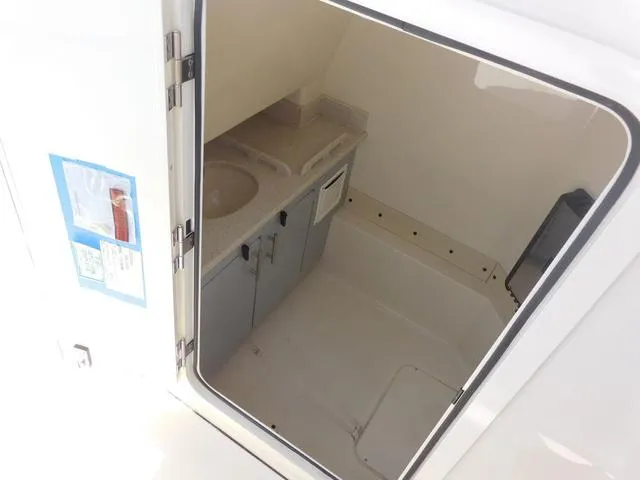 Slide: The Image of 2024 Stingray 253CC boat interior with sink and storage cabinets. - 31