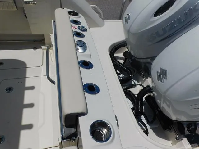 Slide: The Image of 2024 Stingray 253CC boat with dual Suzuki outboard motors and fishing rod holders. - 46