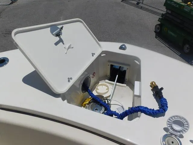Slide: The Image of 2024 Stingray 253CC boat compartment with open hatch and coiled hose. - 7