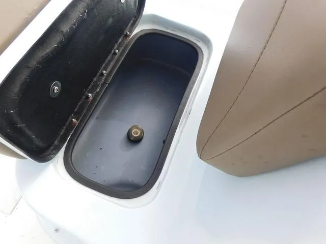Slide: The Image of Open storage compartment in 2018 Excel Boats Bay Pro 220 with brown seating. - 12