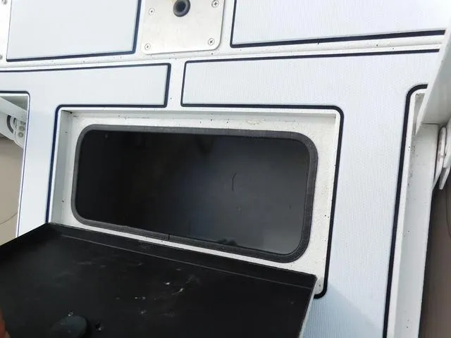 Slide: The Image of 2018 Excel Boats Bay Pro 220 storage compartment with open lid, showcasing interior space. - 18