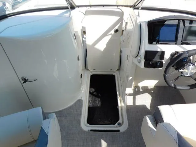 Slide: The Image of 2024 Stingray 231DC boat interior with helm, seating, and storage compartment. - 11