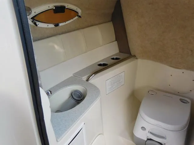 Slide: The Image of 2024 Stingray 231DC boat interior with sink and toilet in compact cabin. - 14