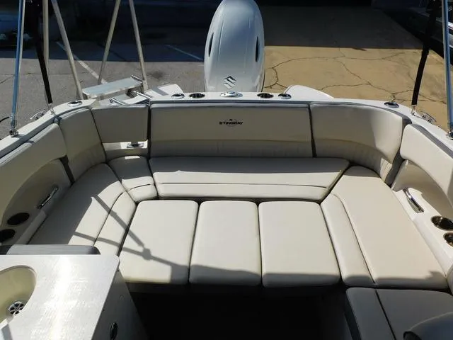 Slide: The Image of 2024 Stingray 231DC boat interior with spacious beige seating and modern design. - 15