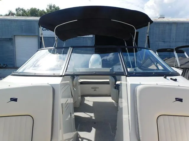 Slide: The Image of 2024 Stingray 231DC boat with black canopy and sleek design, docked outdoors. - 5