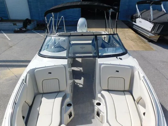 Slide: The Image of 2024 Stingray 231DC boat with spacious seating and sleek design in a marina setting. - 6