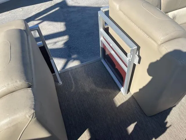 Slide: The Image of 2020 Starcraft LX 22 R boat interior with beige seating and open gate. - 16
