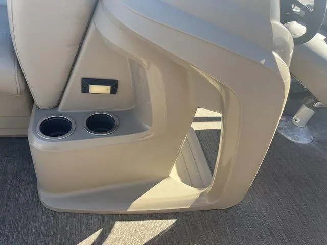 Slide: The Image of 2020 Starcraft LX 22 R boat interior with cup holders and beige seating. - 17