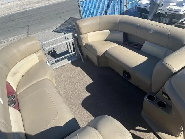 Slide: The Image of 2020 Starcraft LX 22 R pontoon boat interior with beige seating and cup holders. - 6