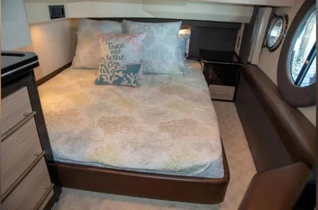 Slide: The Image of Luxurious 2011 Marquis Sport Coupe bedroom with tropical-themed bedding and elegant porthole windows. - 22