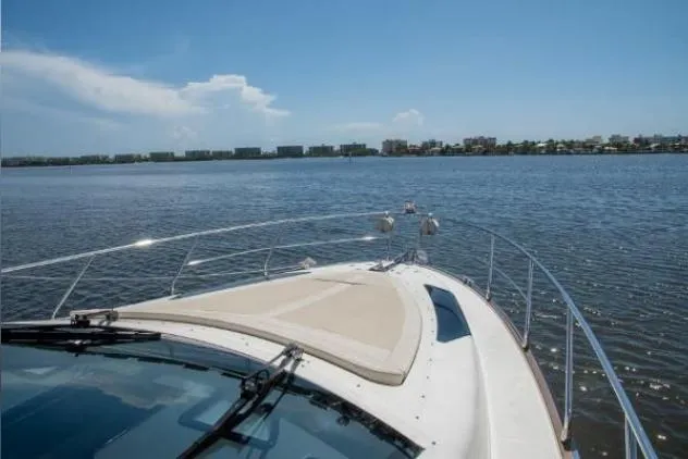 Slide: The Image of 2011 Marquis Sport Coupe yacht with elegant deck seating and wooden table. - 8