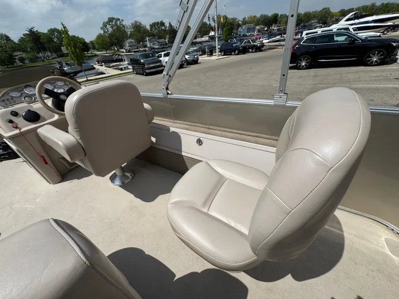 Slide: The Image of 2014 Sylvan Mirage Fish 8520 CNF boat interior with beige seating and steering console. - 13