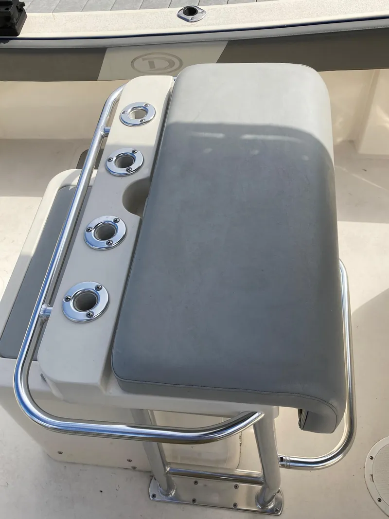 Slide: The Image of Defiance Commander 2022 boat seat with rod holders and cushioned backrest. - 11