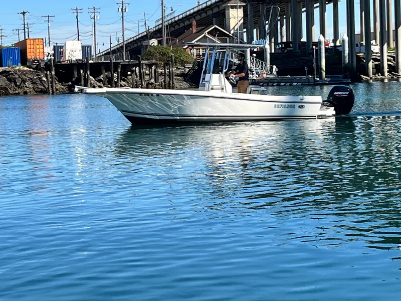 Slide: The Image of 2022 Defiance Commander boat on calm water near a bridge and industrial area. - 17