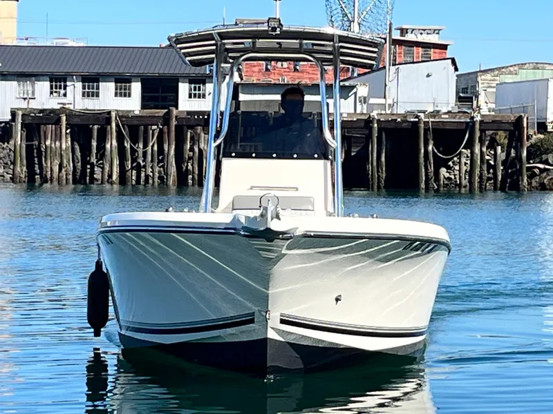 Slide: The Image of 2022 Defiance Commander boat on calm water near a dock. - 2