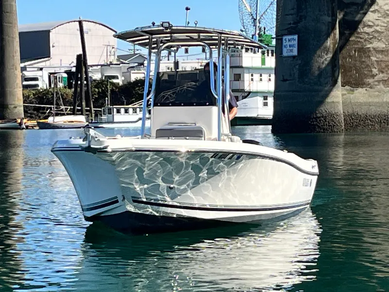 Slide: The Image of 2022 Defiance Commander boat on calm water near a bridge. - 21