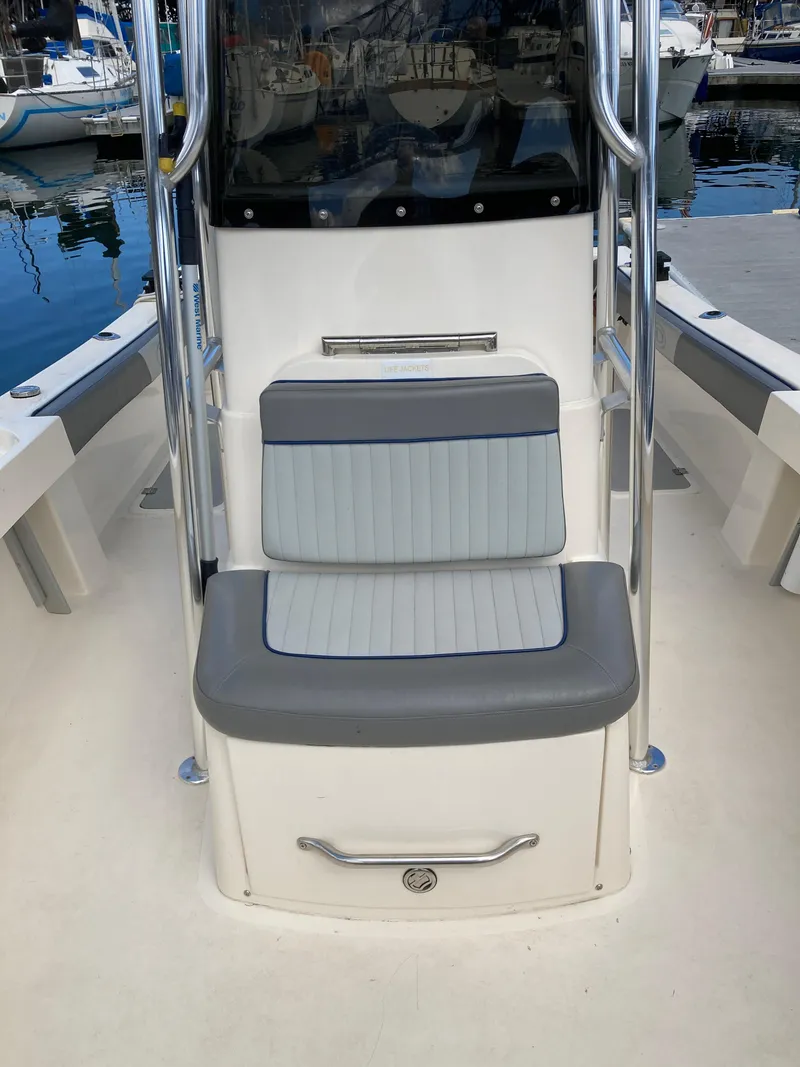 Slide: The Image of 2022 Defiance Commander boat interior with cushioned seating at a marina. - 5