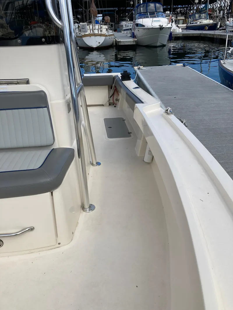 Slide: The Image of 2022 Defiance Commander boat docked at marina with seating and railing. - 7