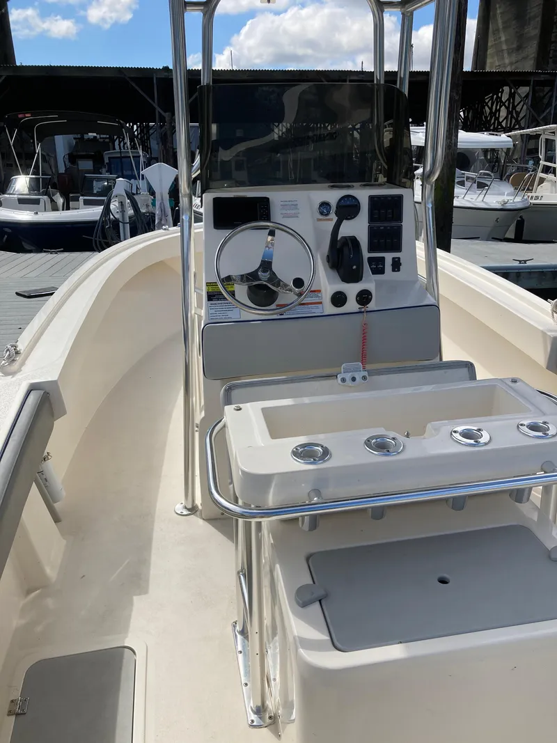 Slide: The Image of 2022 Defiance Commander boat interior with steering console and seating, docked at marina. - 8