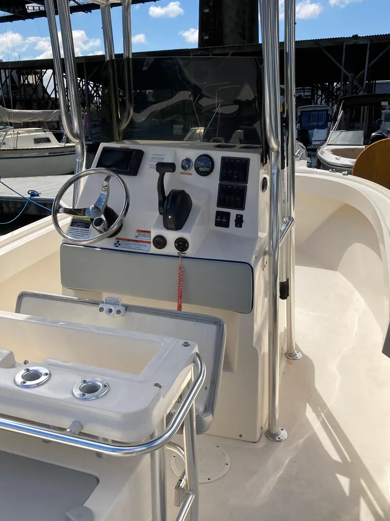 Slide: The Image of 2022 Defiance Commander boat console with steering wheel and controls, docked at marina. - 9