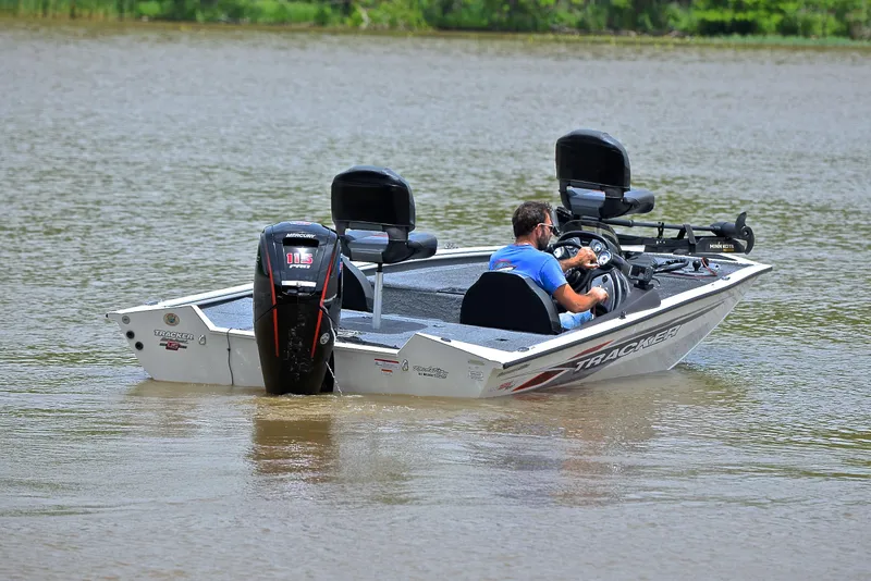 Slide: The Image of 2023 Bass Tracker Pro Team 195 TXE boat on a calm lake. - 8