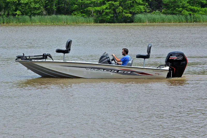 Slide: The Image of 2023 Bass Tracker Pro Team 195 TXE boat on a calm lake. - 9