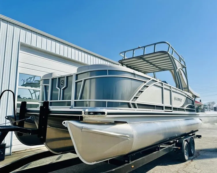 Slide: The Image of 2025 Godfrey Monaco Sundeck 235 SD pontoon boat on trailer, parked outdoors. - 4