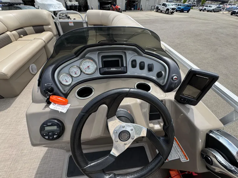 Slide: The Image of 2021 Sun Tracker Party Barge 20 DLX dashboard with steering wheel and gauges. - 10