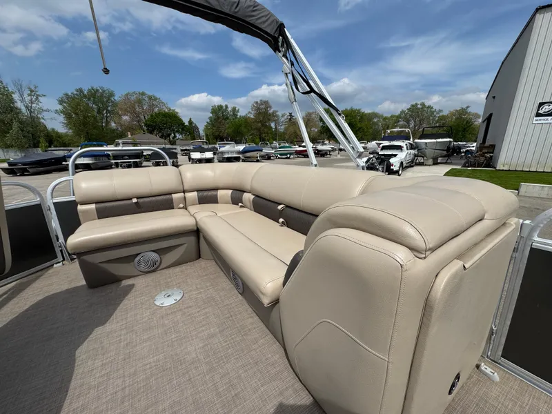 Slide: The Image of 2021 Sun Tracker Party Barge 20 DLX with beige seating and spacious deck under blue sky. - 6