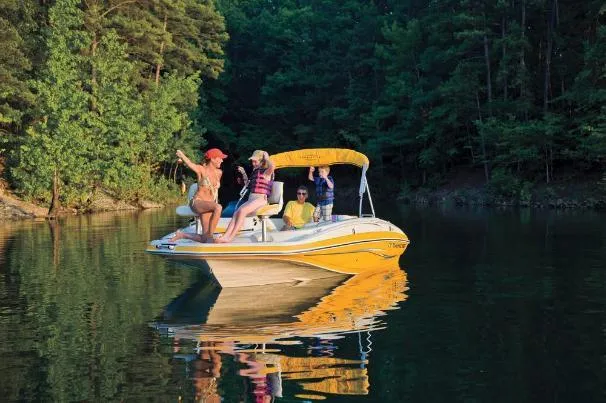 Slide: The Image of People enjoying a day on a 2012 Tahoe 195 boat in a serene lake setting. - 1