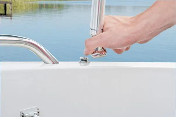 Slide: The Image of Hand adjusting a fixture on a 2012 Tahoe 195 boat near water. - 29