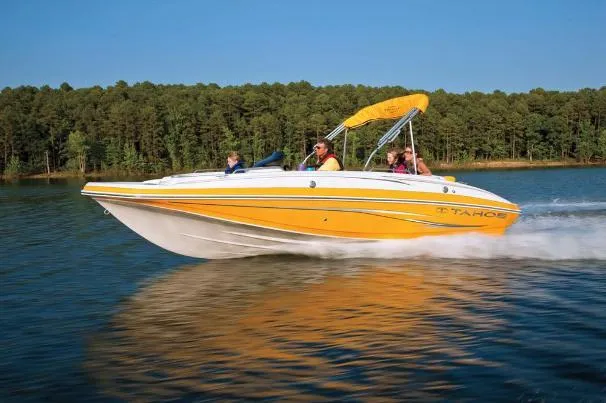Slide: The Image of 2012 Tahoe 195 boat cruising on a lake with forested shoreline. - 4