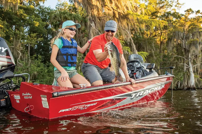 Slide: The Image of Man and girl fishing on 2023 Tracker Pro Team 175 TXW boat, holding a large fish. - 8