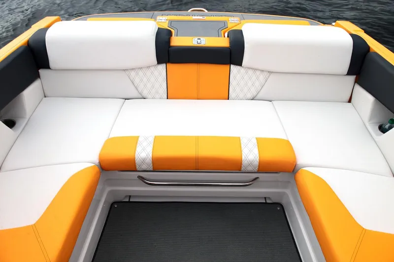 Slide: The Image of 2016 Glastron GTS 207 boat interior with orange and white seating, on water. - 10