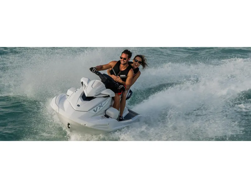 Slide: The Image of 2025 Yamaha Boats VX Cruiser jet ski with two riders enjoying a thrilling water ride. - 6