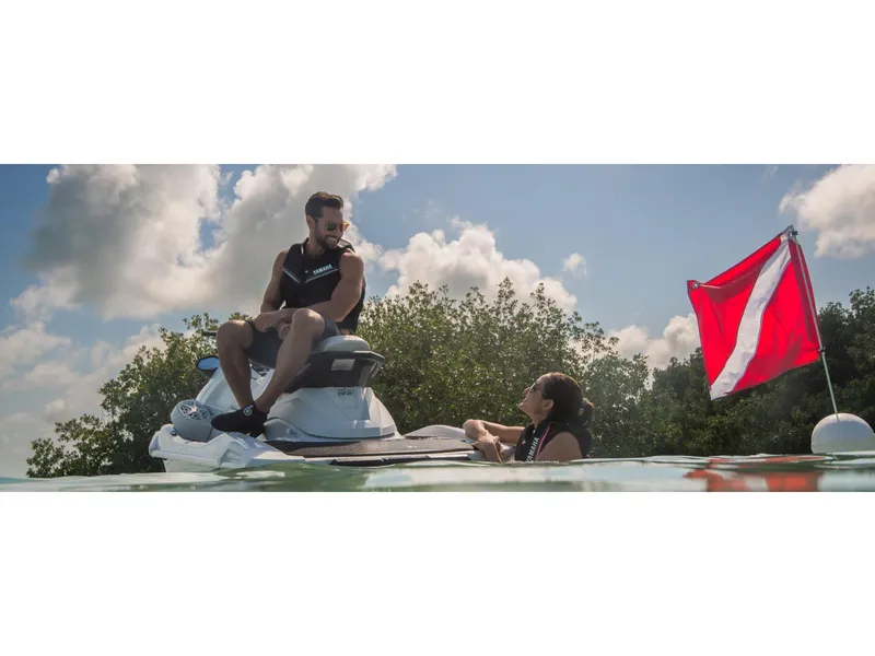 Slide: The Image of 2025 Yamaha VX Cruiser on water with two people, red flag, and cloudy sky. - 7