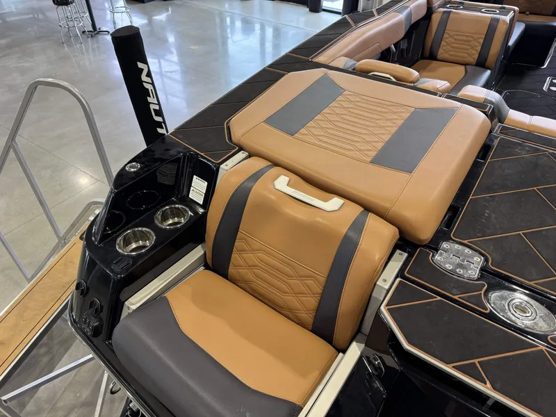 Slide: The Image of 2023 Malibu Wakesetter 26 LSV interior with tan and black seating, cup holders, and sleek design. - 10