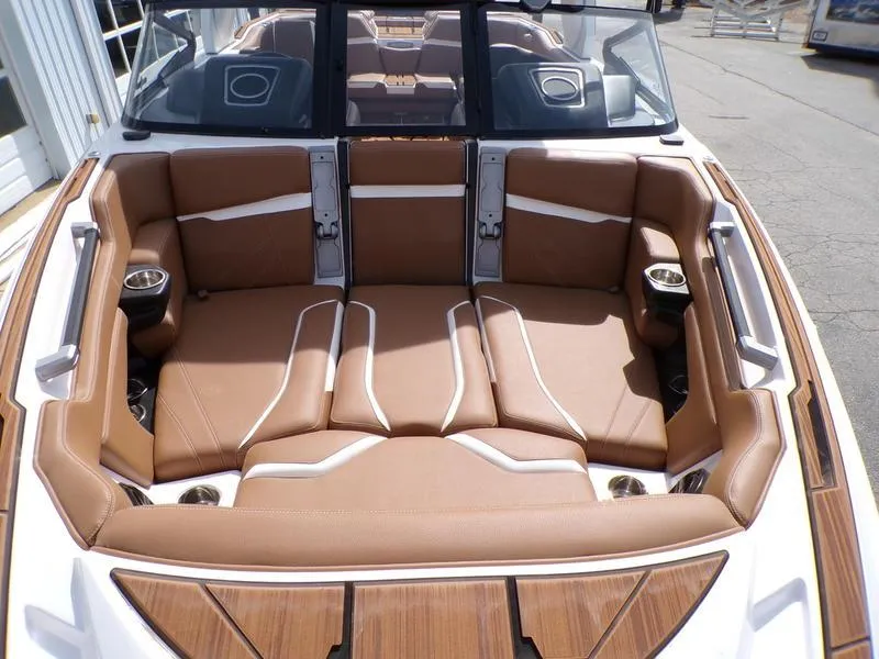 Slide: The Image of 2023 Supra SL 450 boat interior with tan leather seating and cup holders. - 17
