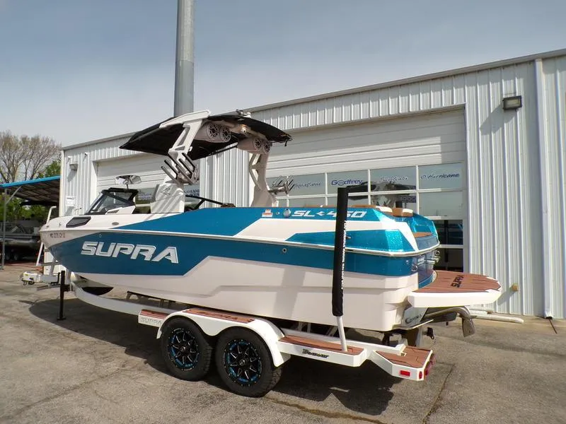 Slide: The Image of 2023 Supra SL 450 boat on trailer outside a building, showcasing sleek design and vibrant colors. - 19