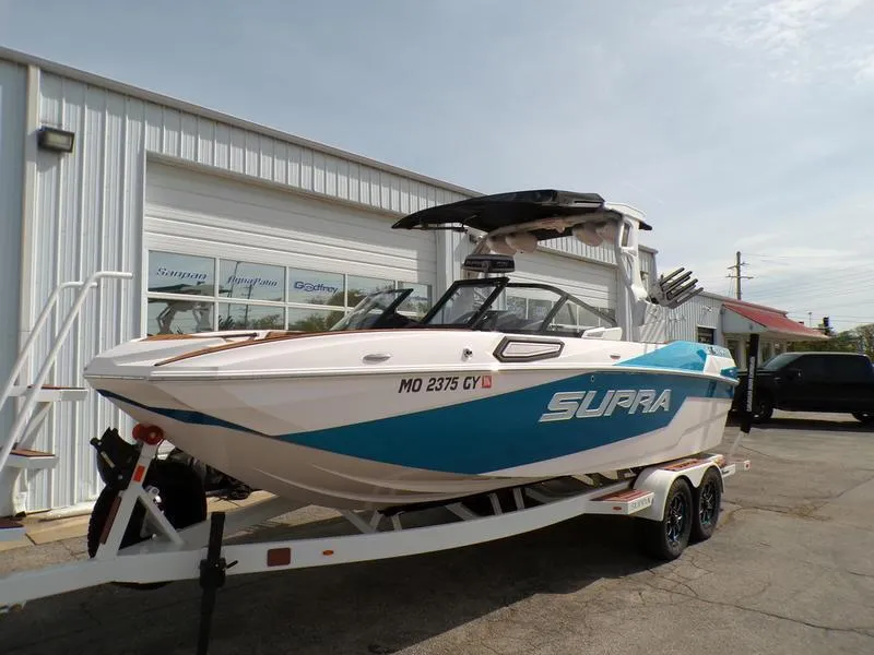 Slide: The Image of 2023 Supra SL 450 boat on trailer, parked outside a building. - 5