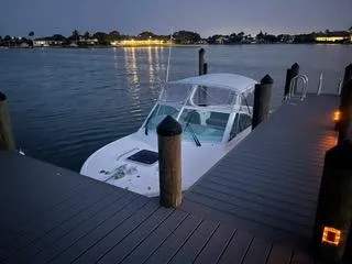 Slide: The Image of 2016 Hunt Yachts Harrier 25 docked at twilight, calm waters, illuminated pier. - 6
