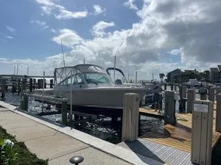 Slide: The Image of 2016 Hunt Yachts Harrier 25 docked at marina under cloudy sky. - 7