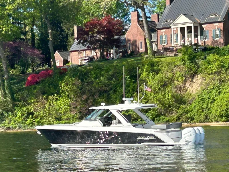 Slide: The Image of 2021 Tiara Yachts 38 LS cruising on a scenic river near elegant brick homes. - 0