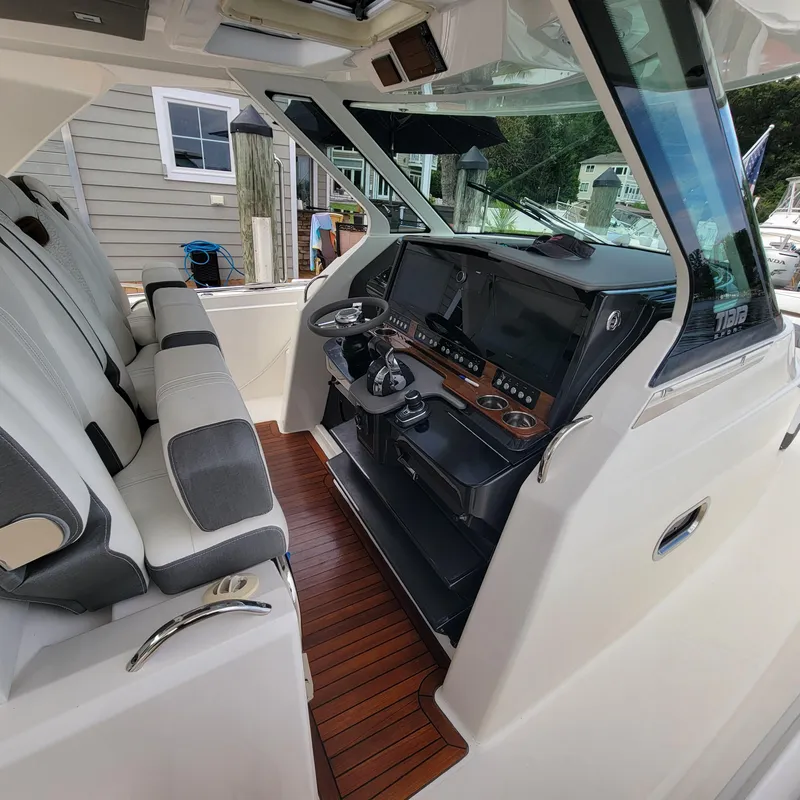 Slide: The Image of 2021 Tiara Yachts 38 LS helm with dual seats and modern navigation controls. - 10