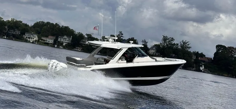 Slide: The Image of 2021 Tiara Yachts 38 LS cruising on a lake under cloudy skies. - 9