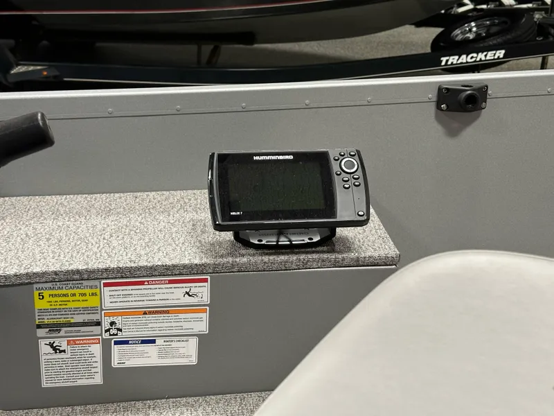 Slide: The Image of 2023 Alumacraft V14 boat interior with a mounted fish finder and safety labels. - 12